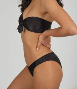 The Swim Ribbed Cheeky Bottom: Jet Black -Outlet No Wire Bras Store 3 on model side ribbed cheeky swim bottom jet black f193655f 4ad7 4e1f 95d2 9ba1542cd823